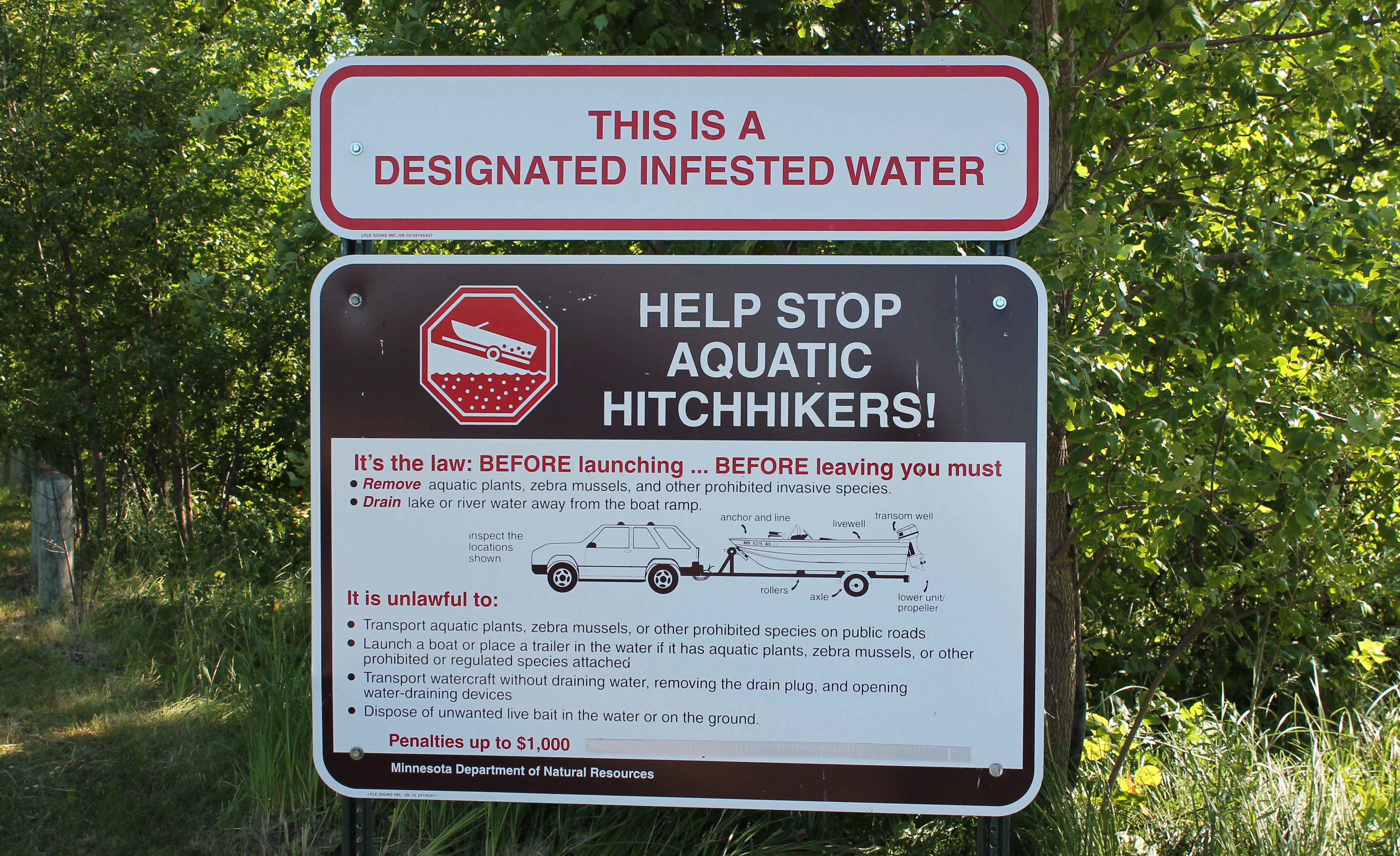 Sign that reads "This is a designated infested water, Help stop aquatic hitchhikers!"