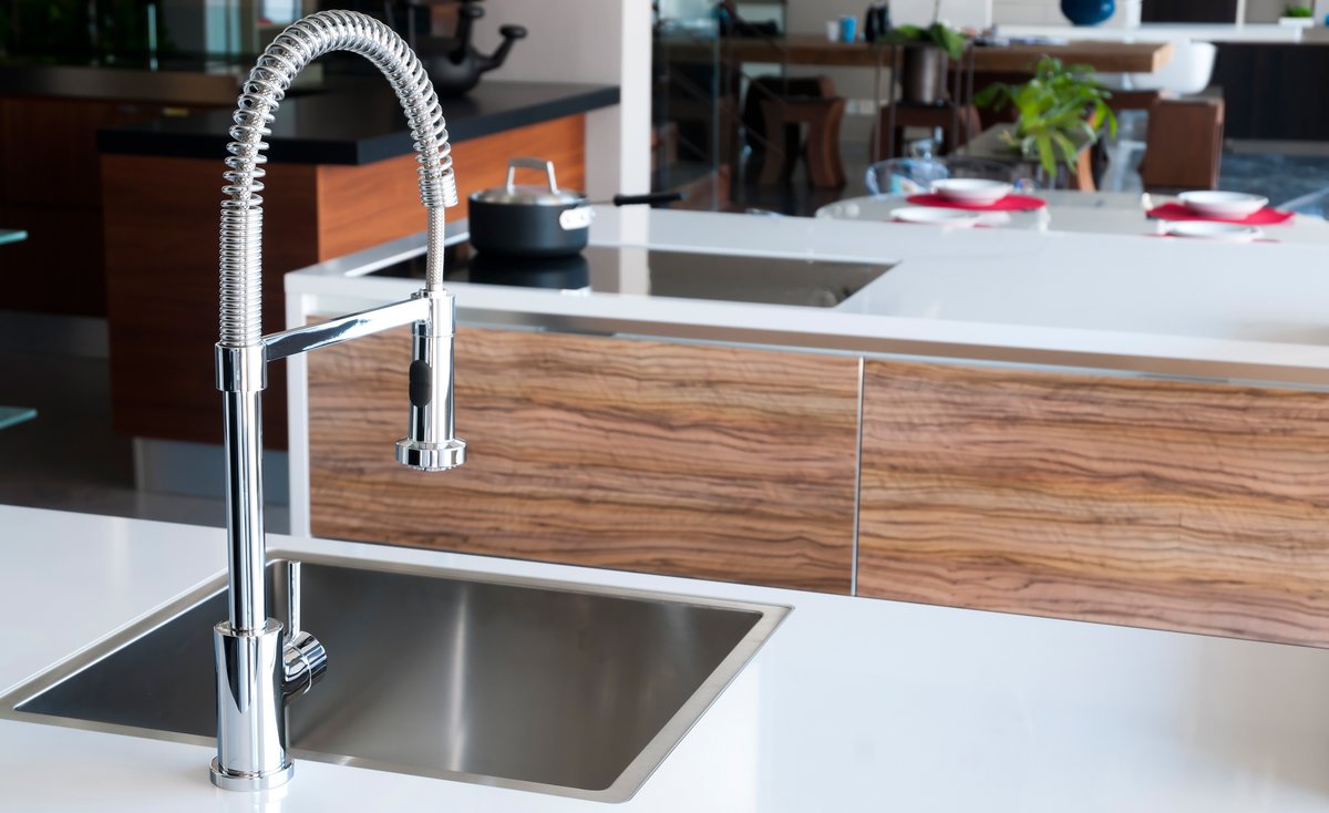 Shiny stainless steel faucet in modern kitchen.