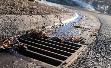 A stormwater drain catches water runoff and leaves
