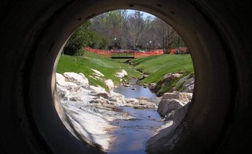Inside of a tunnel, water flows into a stream